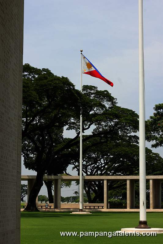The Philippine Flag inside Manila American Cemetery and Memorial with west hemicycle in background.