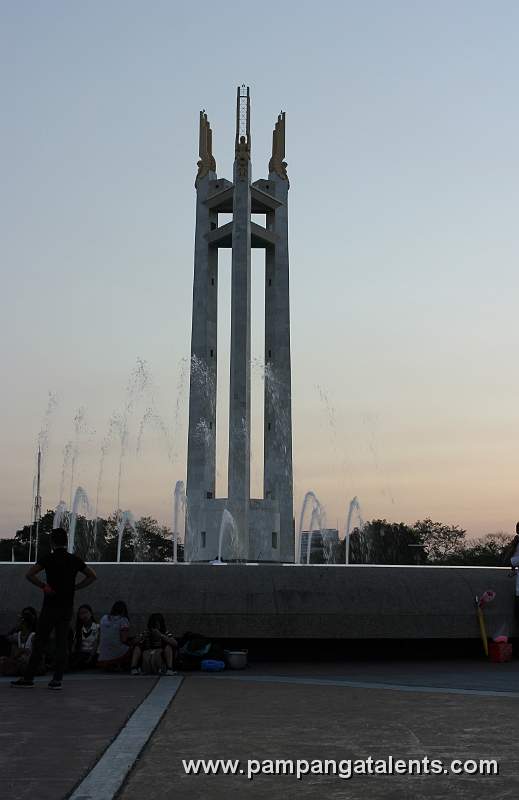 Picnic goers with Quezon Memorial Fountain in background.
