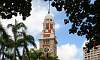 Clock Tower between trees and palms  Location: Kowloon Public Pier - Hong Kong